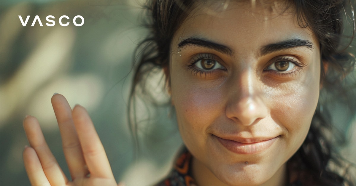 Una donna con occhi espressivi saluta con la mano, mostrando come salutare in diverse lingue.