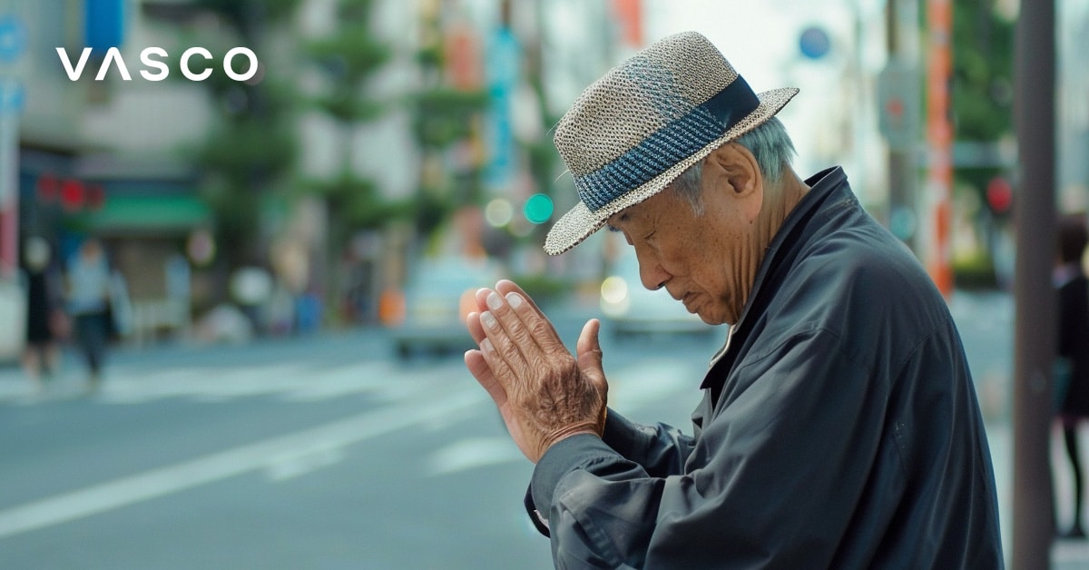 Un uomo anziano che si inchina con le mani giunte, rappresenta il modo di salutare in giapponese.