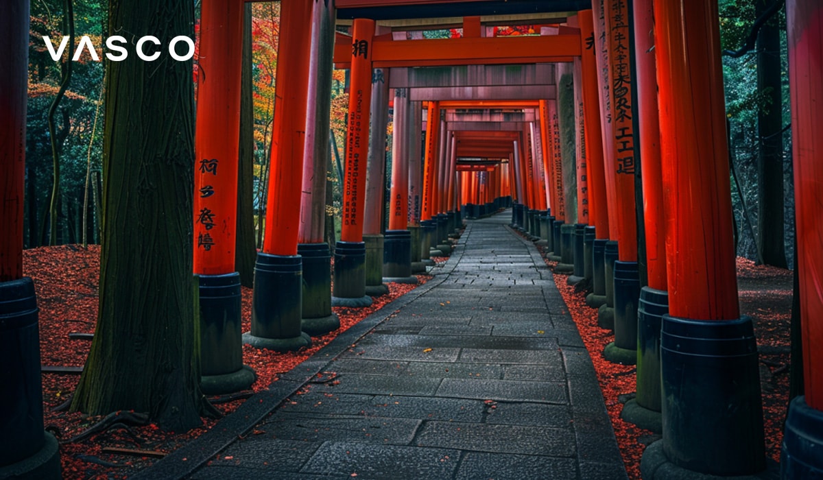 Un sentiero fiancheggiato da vivaci torii rossi in un ambiente forestale sereno.