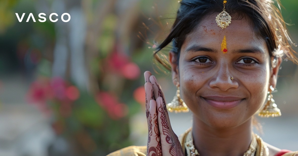 Una donna in abiti tradizionali indiani con le mani in un gesto di saluto, che raffigura come salutare in diverse linguengue.