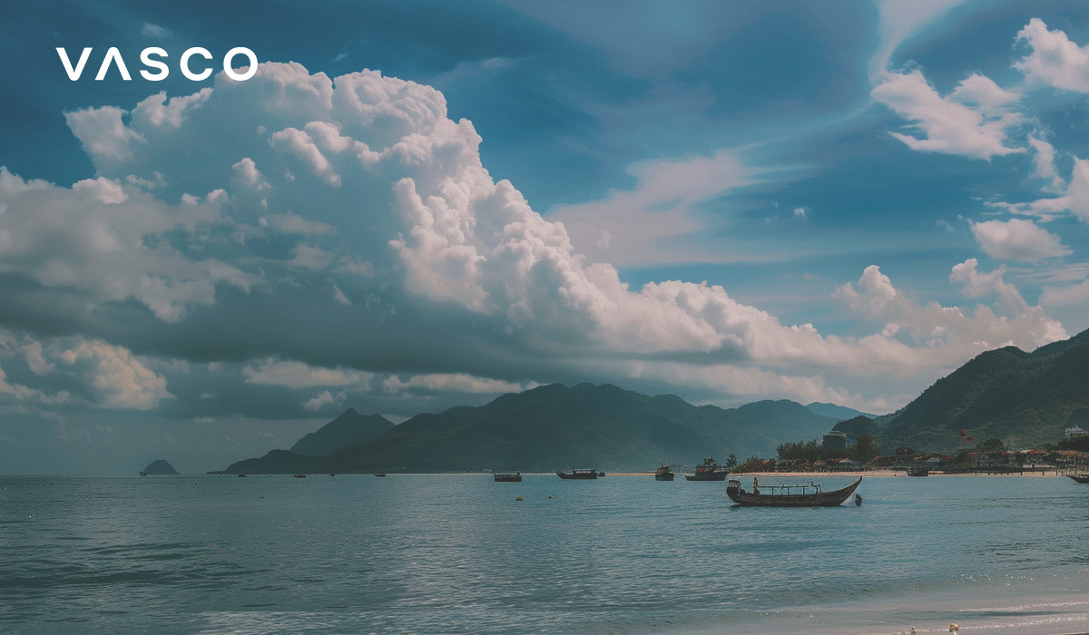 Una spiaggia con barche e montagne sullo sfondo, che illustra il momento migliore per andare in Vietnam.