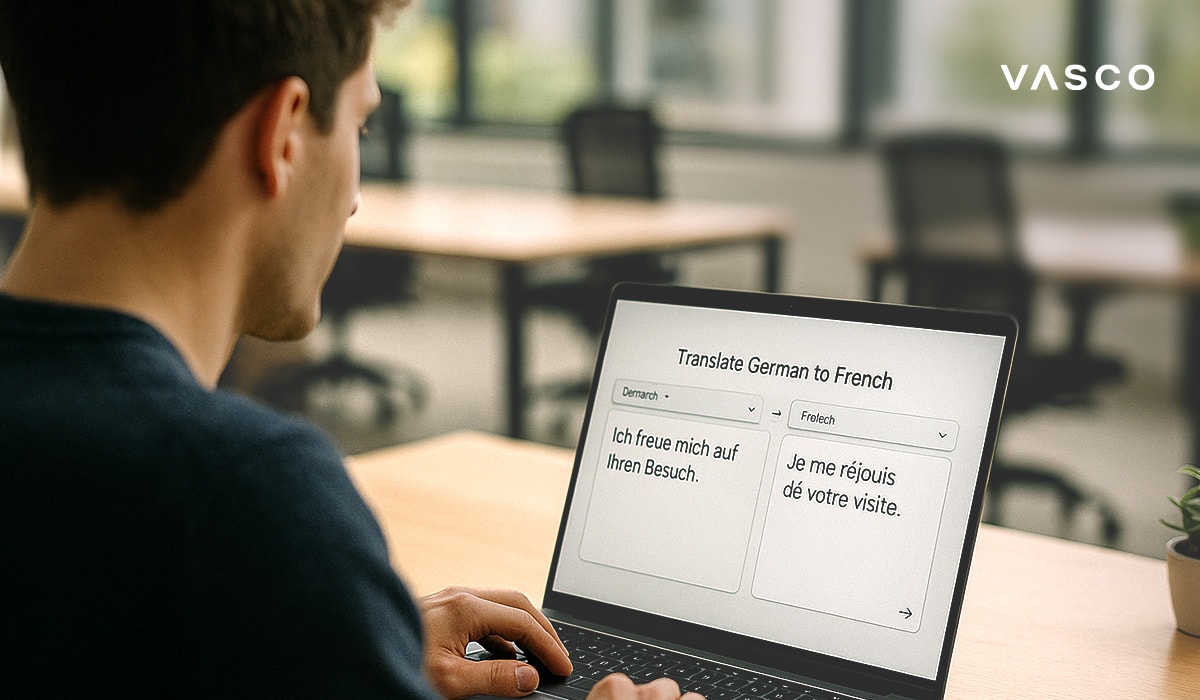 Un uomo usa un laptop per tradurre una frase dal tedesco al francese in uno spazio di lavoro moderno.