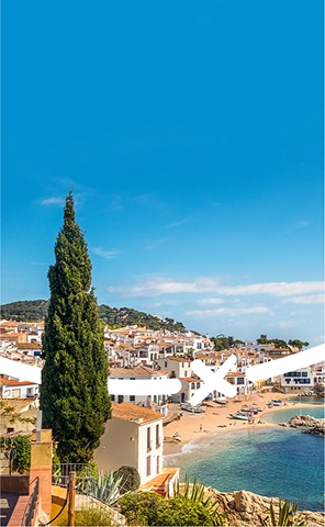 Vista della costa e della città vicina a Fang Aventura, Girona, con le sue scogliere frastagliate, le acque blu e i dintorni urbani panoramici.