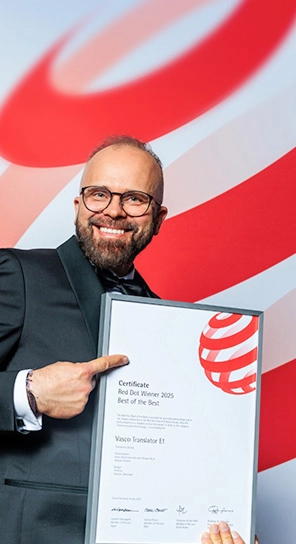 Il CEO di Vasco Electronics con in mano il premio Red Dot, mentre mostra i dispositivi premiati.
